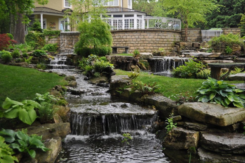 paysagiste-ROCBARON-min_landscaping-rock-louisville-ky-traditional-landscape-and-boulders-brick-wall-bushes-grass-koi-law